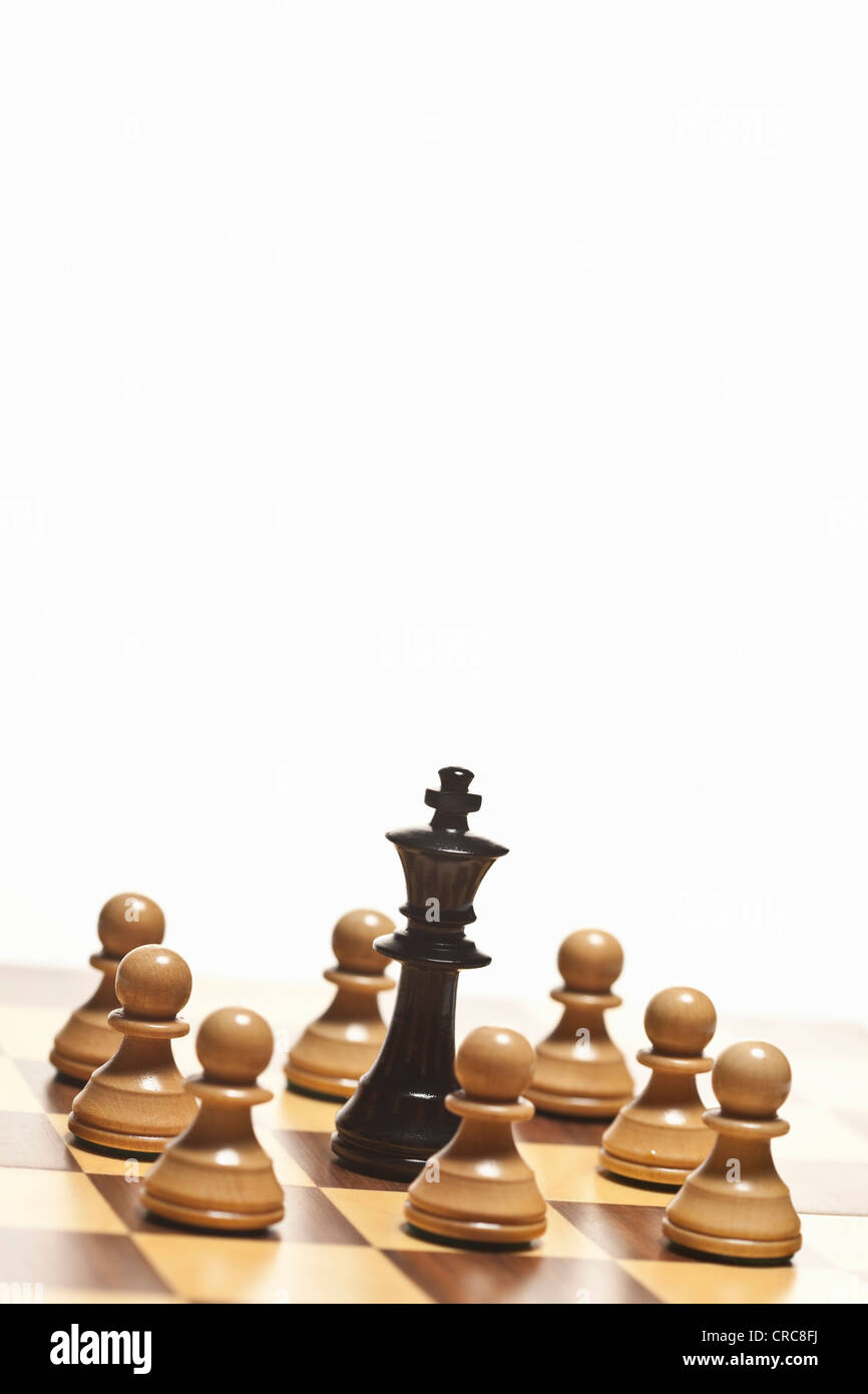 White pawns surrounding black chess king Stock Photo