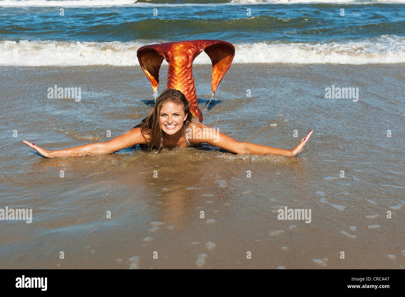 Young mermaid playing in the surf in Virginia Beach, Virginia. Stock Photo
