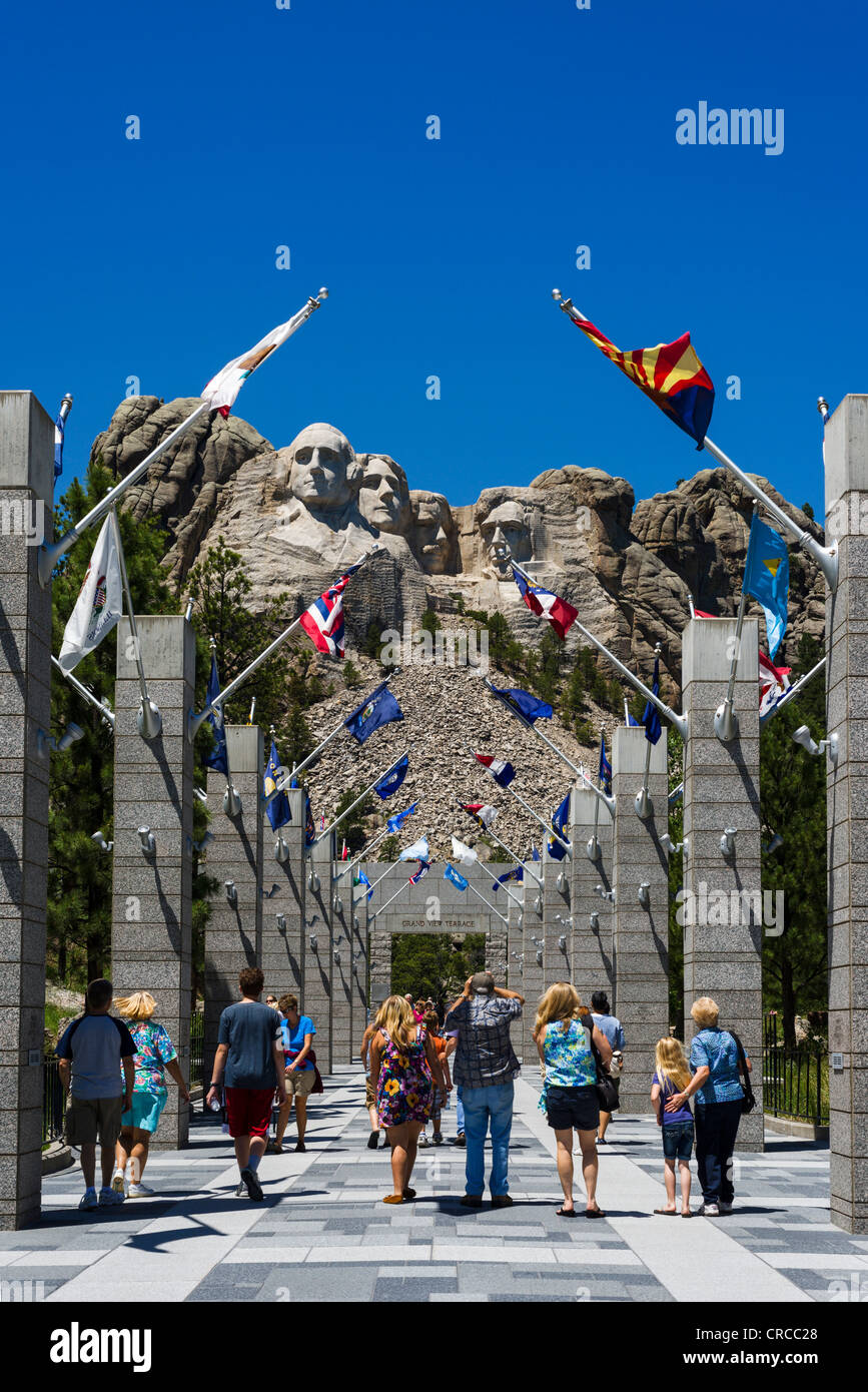 Tourists at Mount Rushmore National Memorial with avenue of state flags leading to viewing area, Black Hills, South Dakota, USA Stock Photo