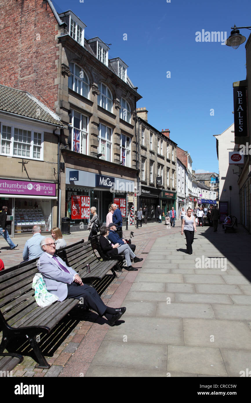 People sitting and walking along Fore Street Hexham Northumberland England UK Stock Photo