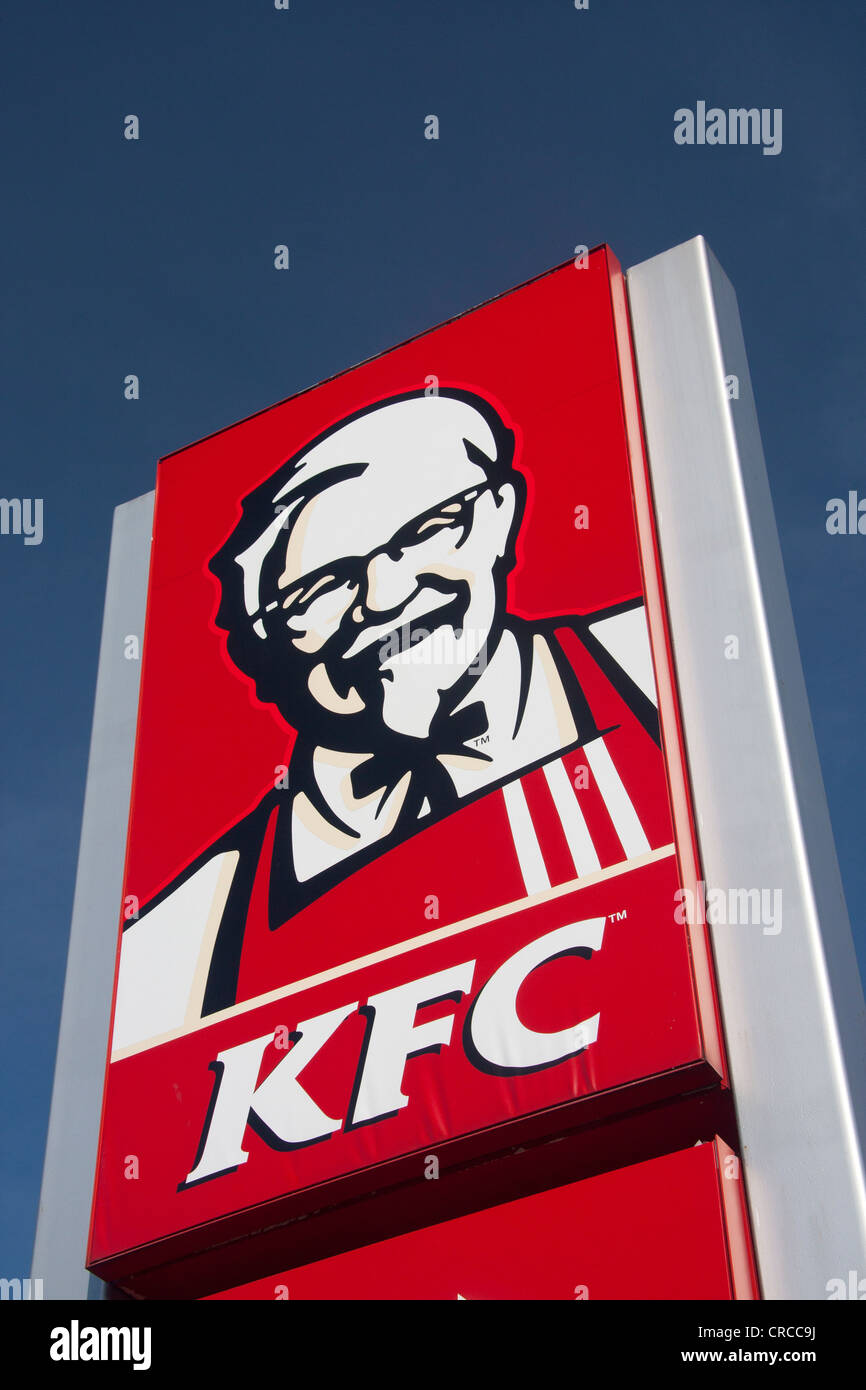 KFC Kentucky Fried Chicken red sign with Colonel Sanders on roadside with blue sky Cardiff Wales UK Stock Photo