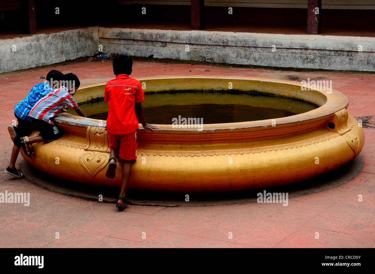 Children staning near a traditional kitchenware of Kerala Stock Photo
