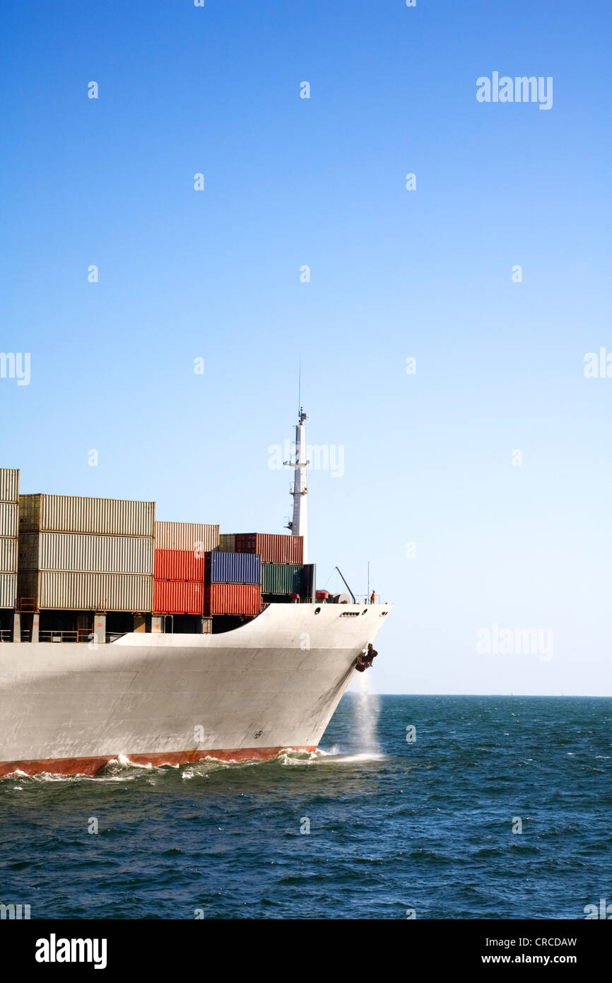Bow of heavily laden container ship at sea under clear blue sky. Normal working ship, cleaned up but now new and perfect. Stock Photo