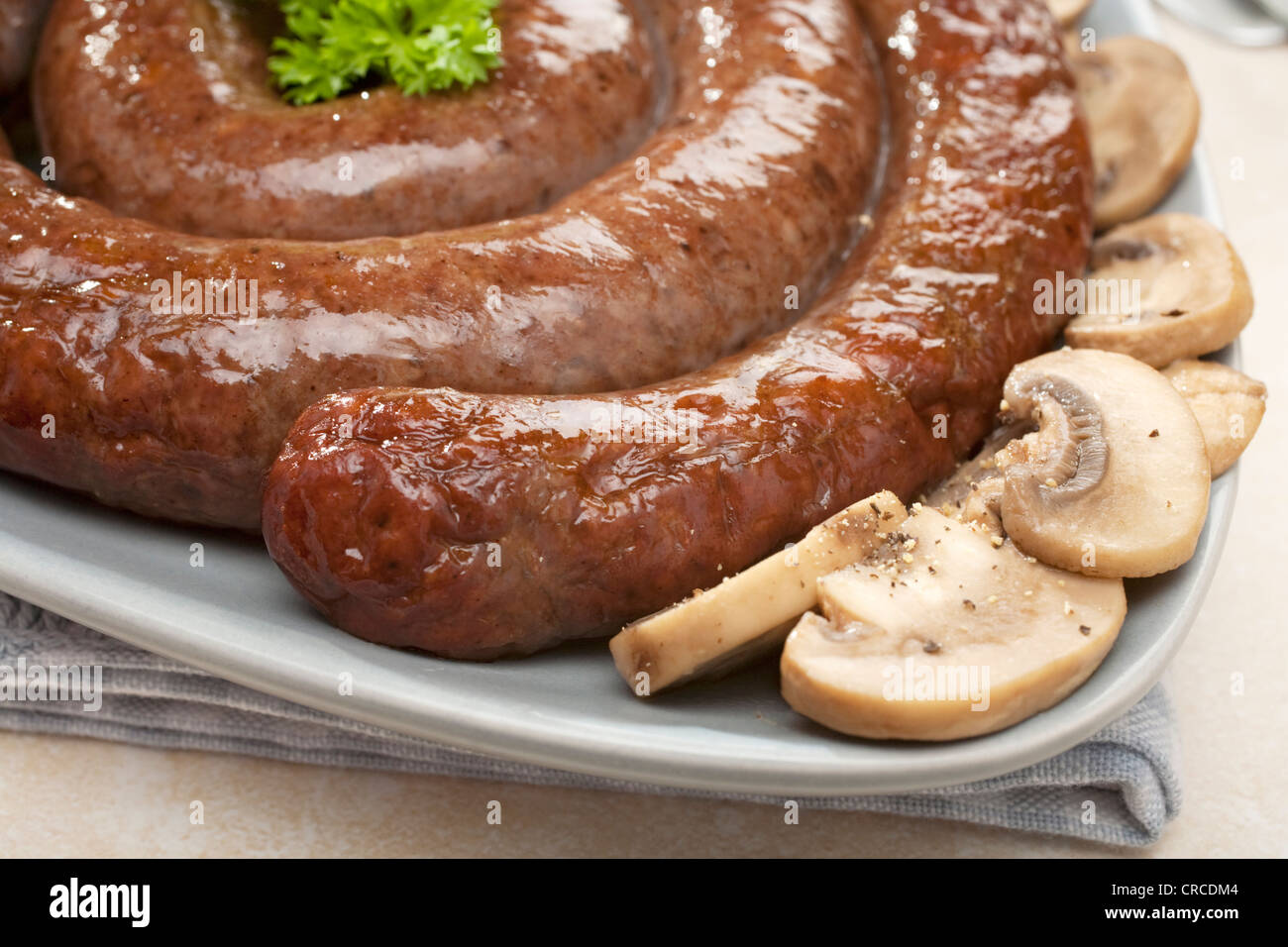 South African sausage coil boerewors grilled and served with mushrooms