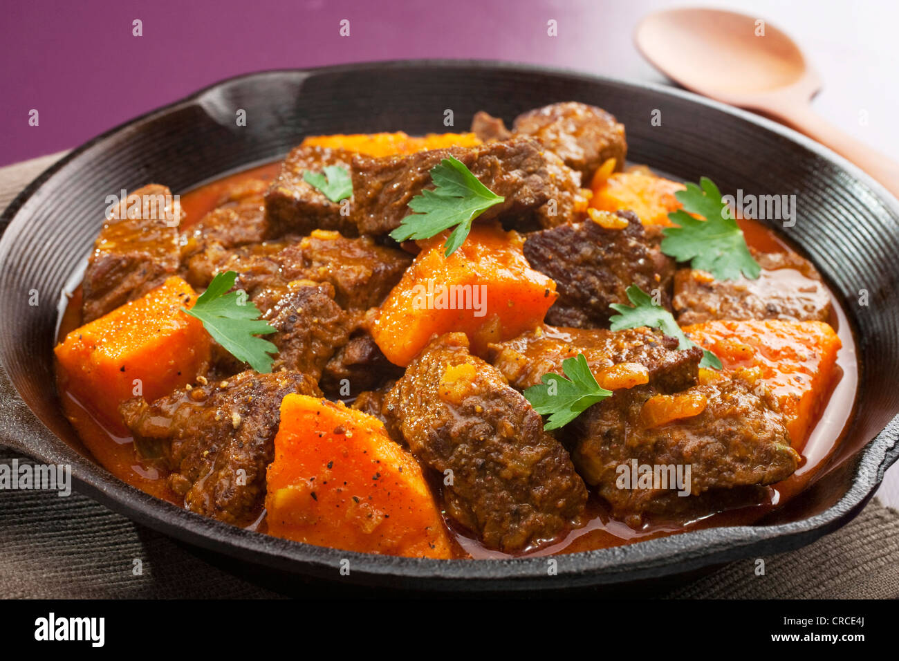 Moroccan tagine or stew of beef with sweet potato, in a cast iron pan. Stock Photo