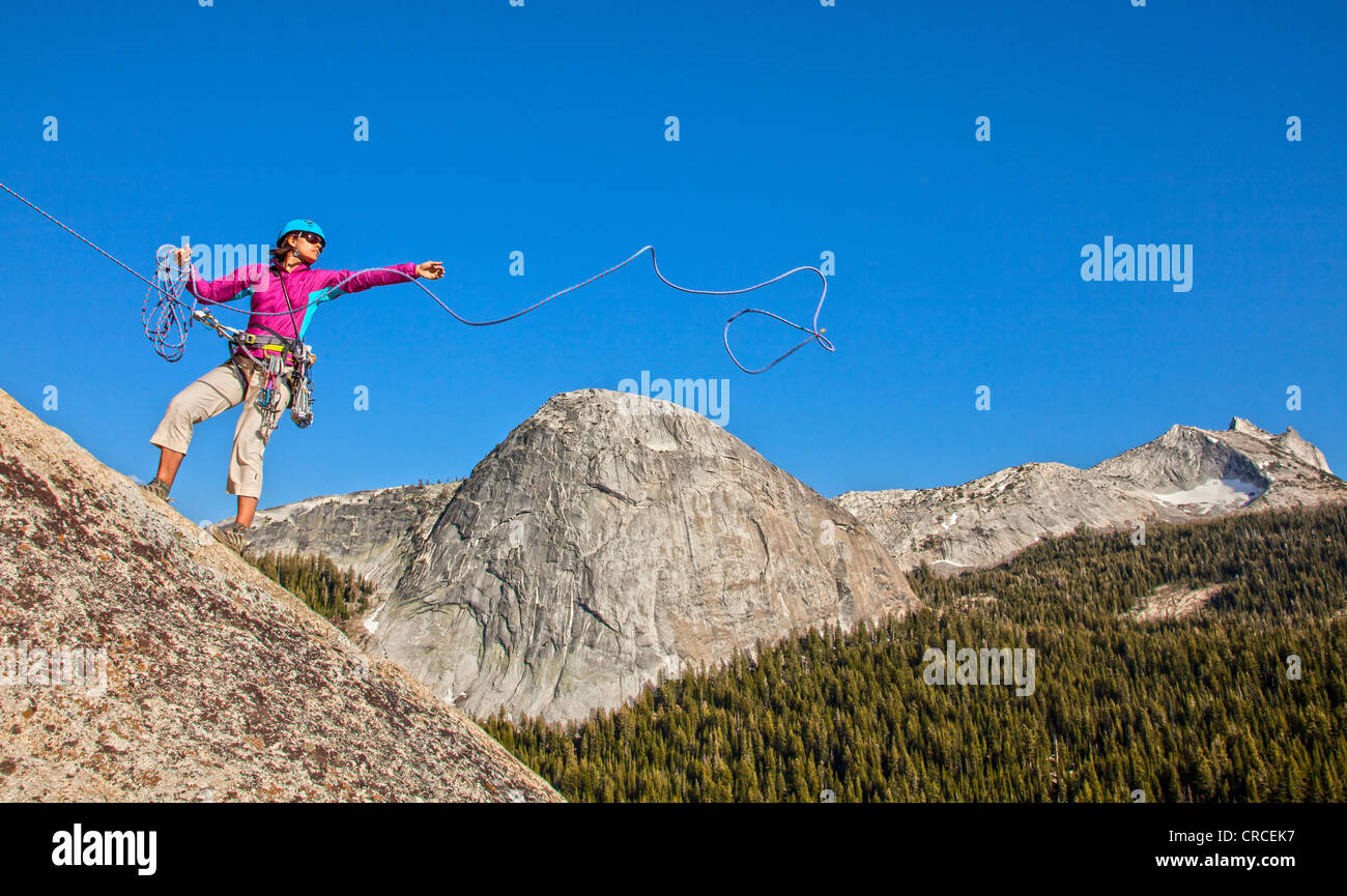 Climber rappelling from the summit after a challenging ascent. Stock Photo