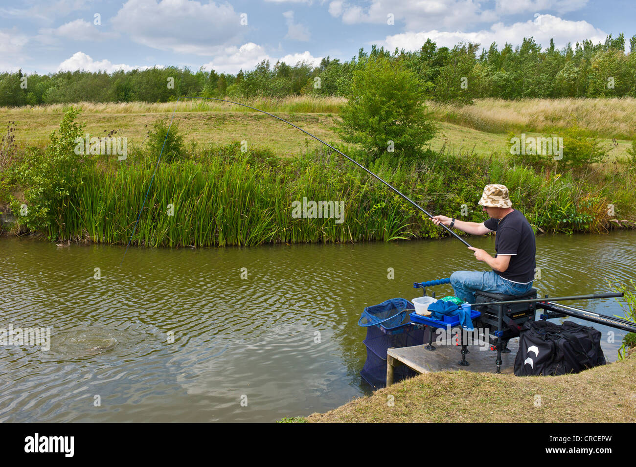 Man pole fishing for carp at Lake near Bagworth, Leicestershire Stock Photo
