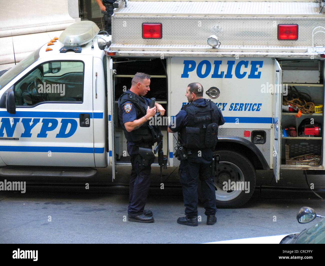 Police car with NYPD writing and heavily armed police officers, USA, New York City, Manhattan Stock Photo