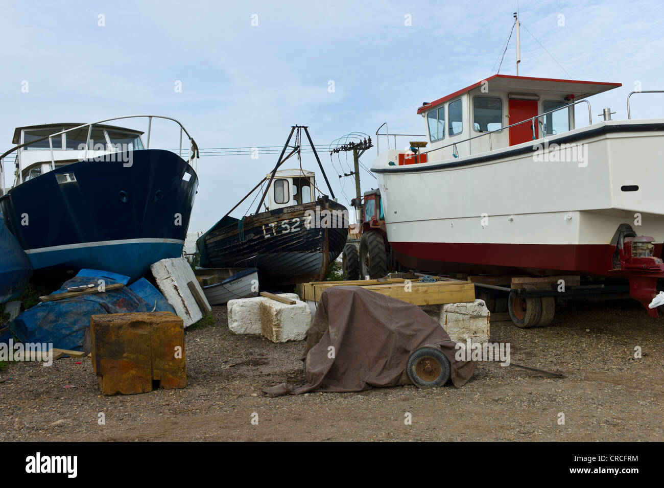 Four different boats on the hard for repair and maintenance work at Southwold Harbour, Suffolk, UK Stock Photo