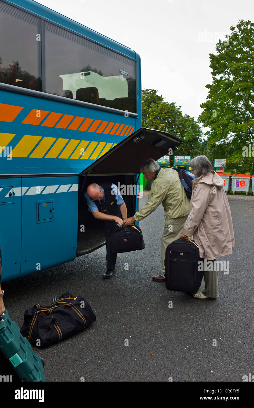 putting luggage on a coach ready for a trip Stock Photo