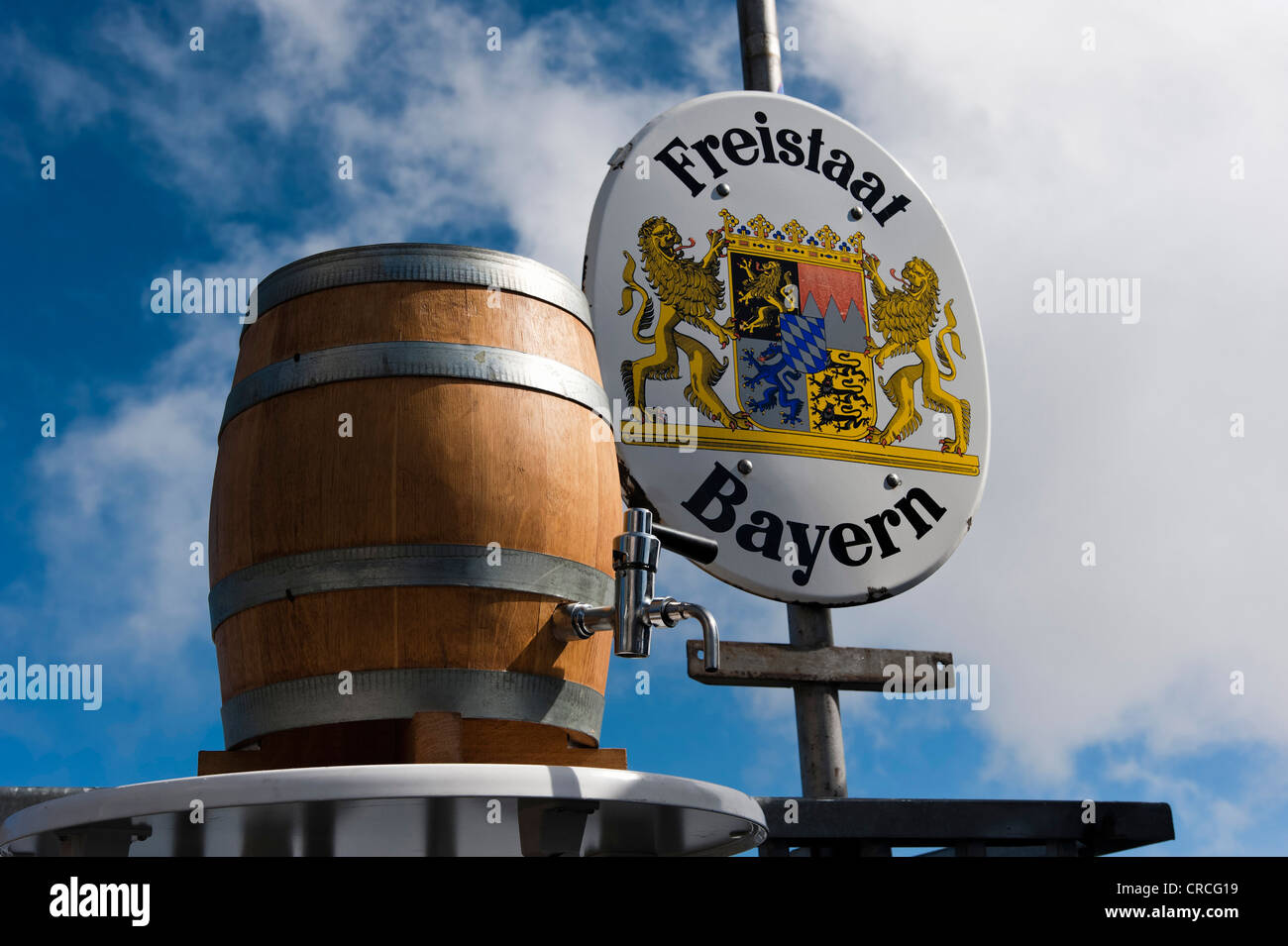 A barrel of beer standing in front of a border sign of the Freistaat Bayern or Free State of Bavaria, mountain station near the Stock Photo