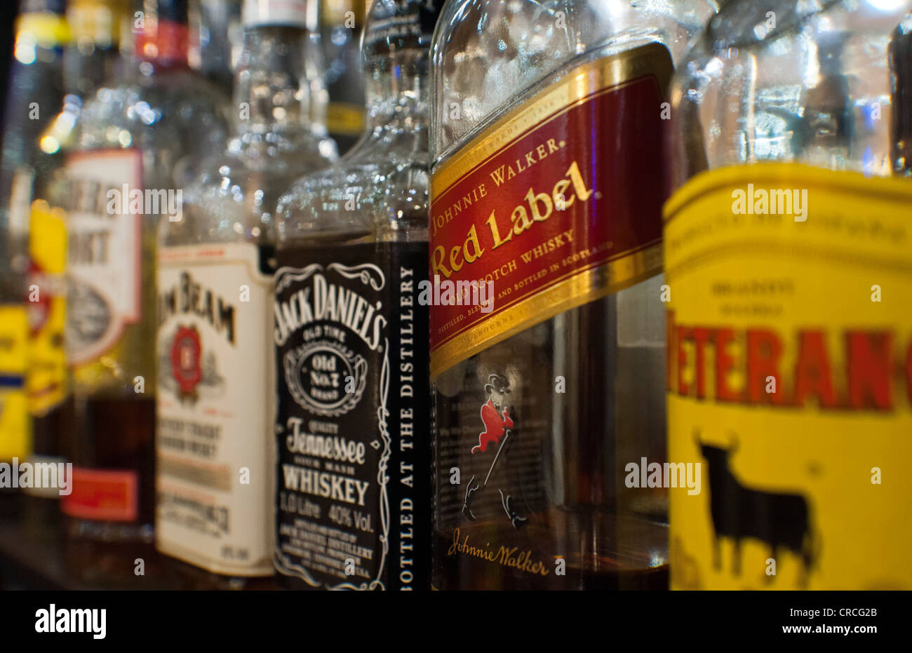 Bottles of various spirits standing on the shelf in a bar Stock Photo