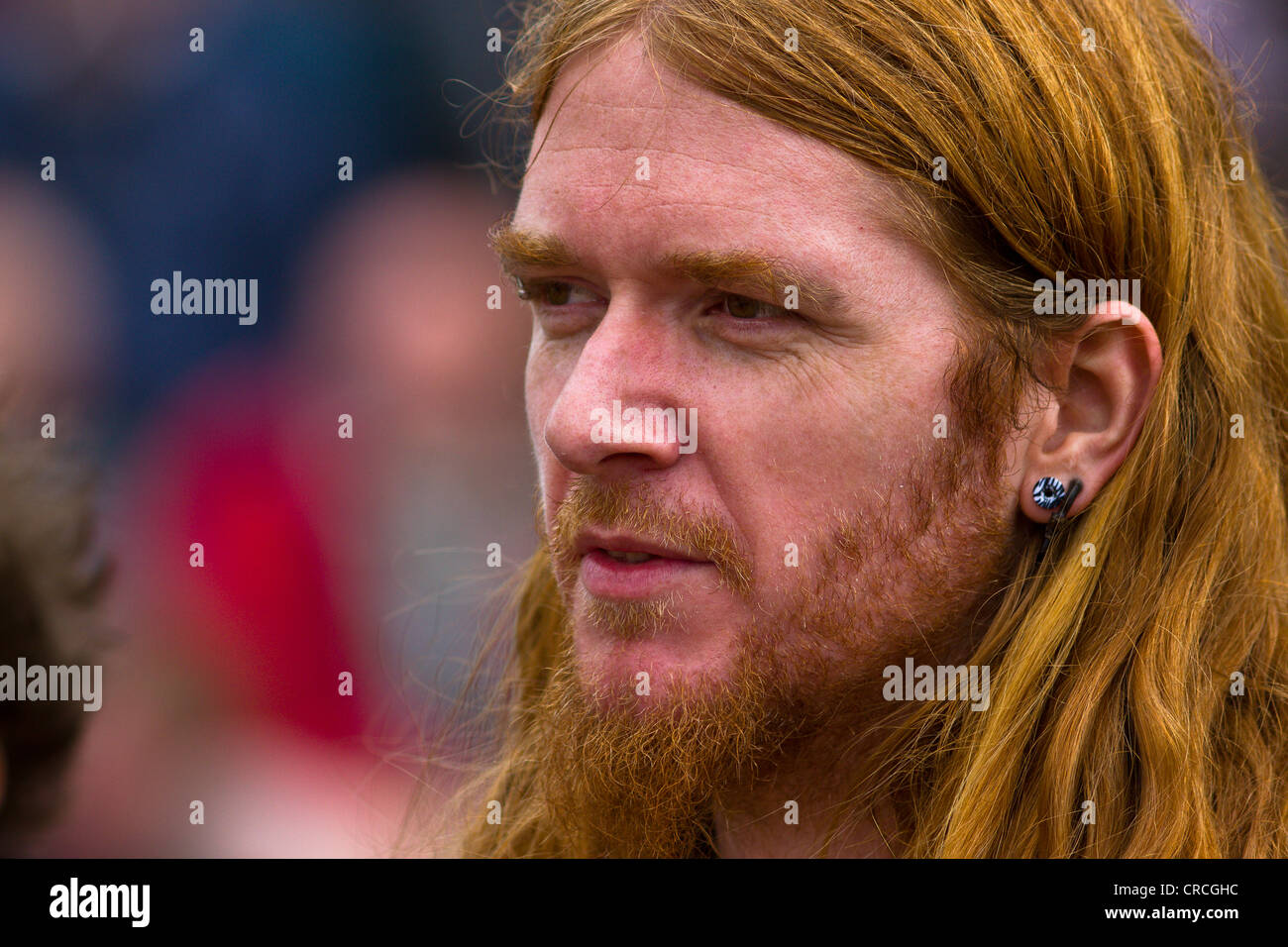 Young ginger male with long hair, beard and ear-ring Stock Photo - Alamy