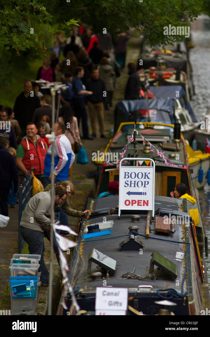 A canal boat being used as a book shop in a View of narrow boats and many people at Leicester Riverside Festival Stock Photo