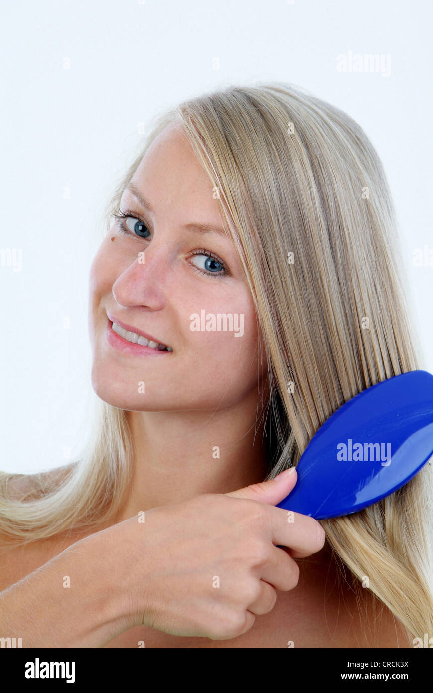 young woman brushes her long blond hair Stock Photo Alamy