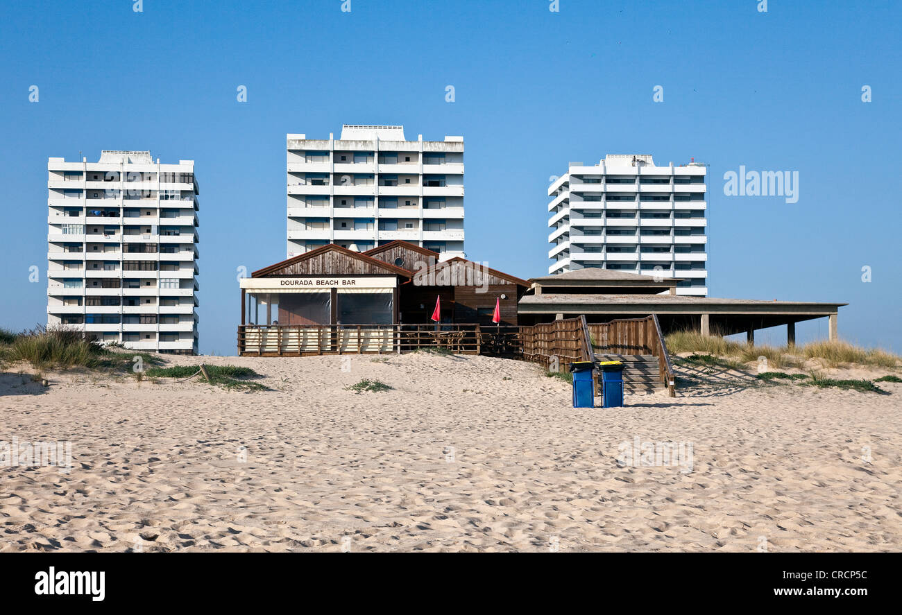 Beach bar, apartment towers at the back, unfinished buildings on the beach of Alvor, Algarve region, Portugal, Europe Stock Photo