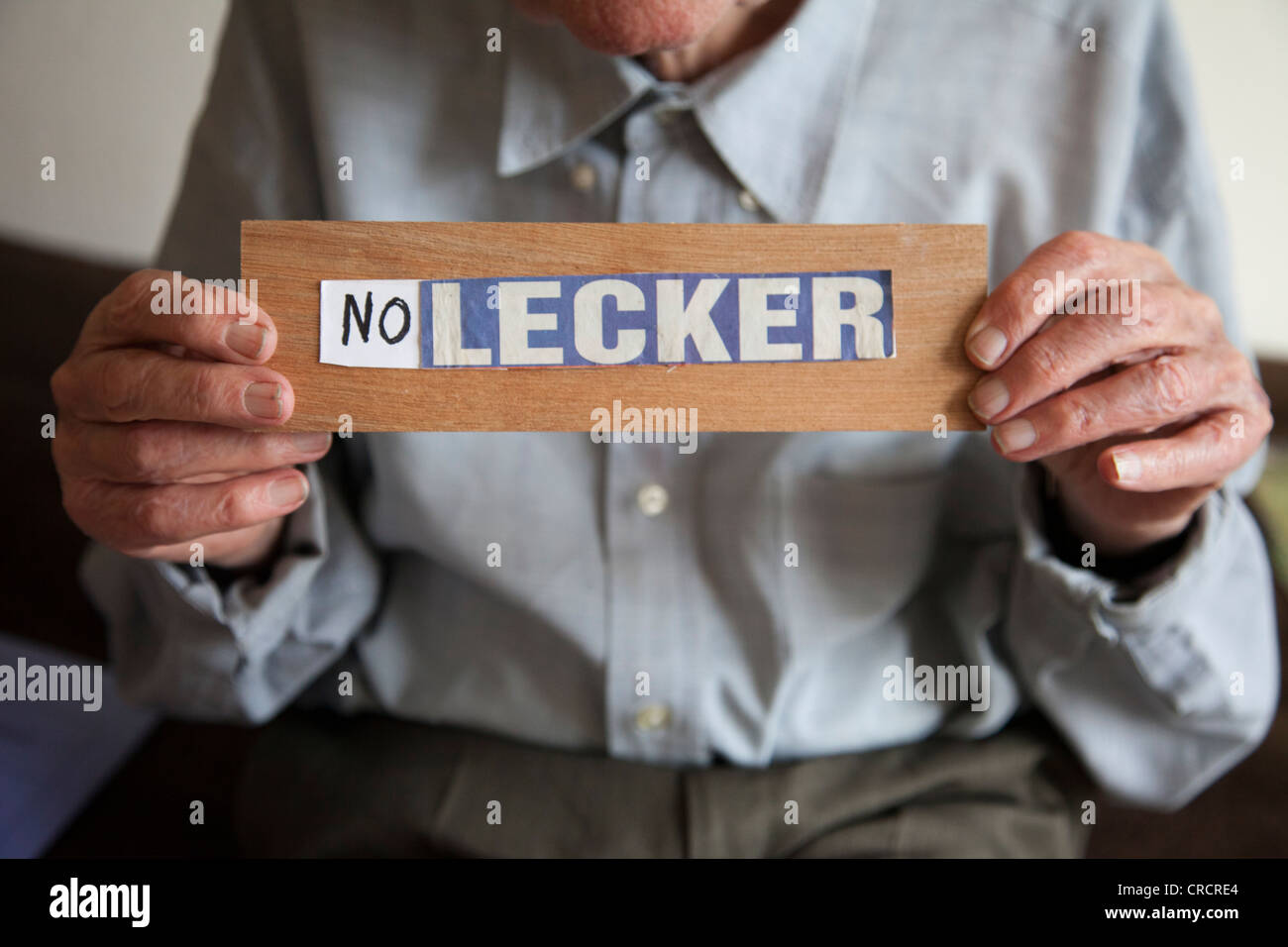 Hands of an elderly man holding up sing 'no lecker', German for 'not tasty', commentary for meal 'not tasty', nursing home Stock Photo