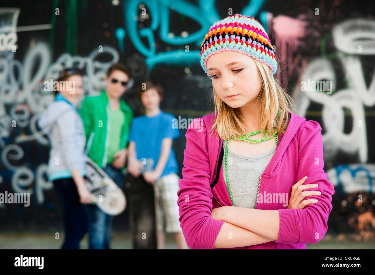 Sad teenage girl with three teenagers in background Stock Photo - Alamy