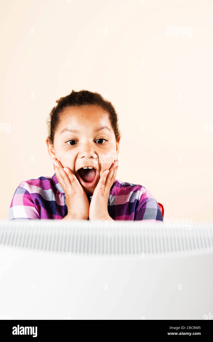 Surprised girl looking at computer monitor Stock Photo