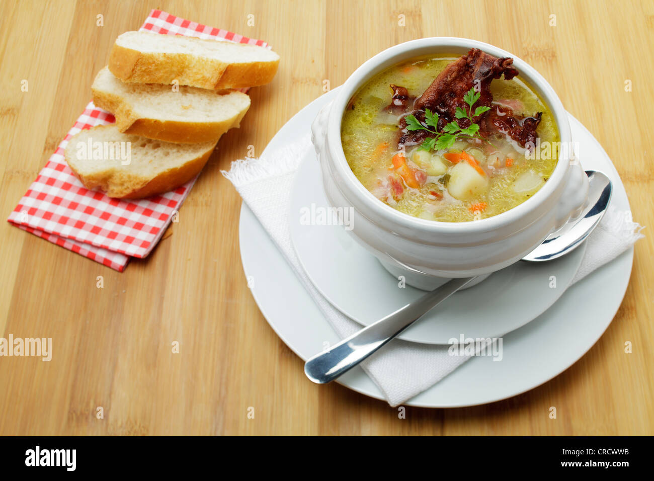 Potato soup with bacon crust served in a terrine, with slices of white bread Stock Photo