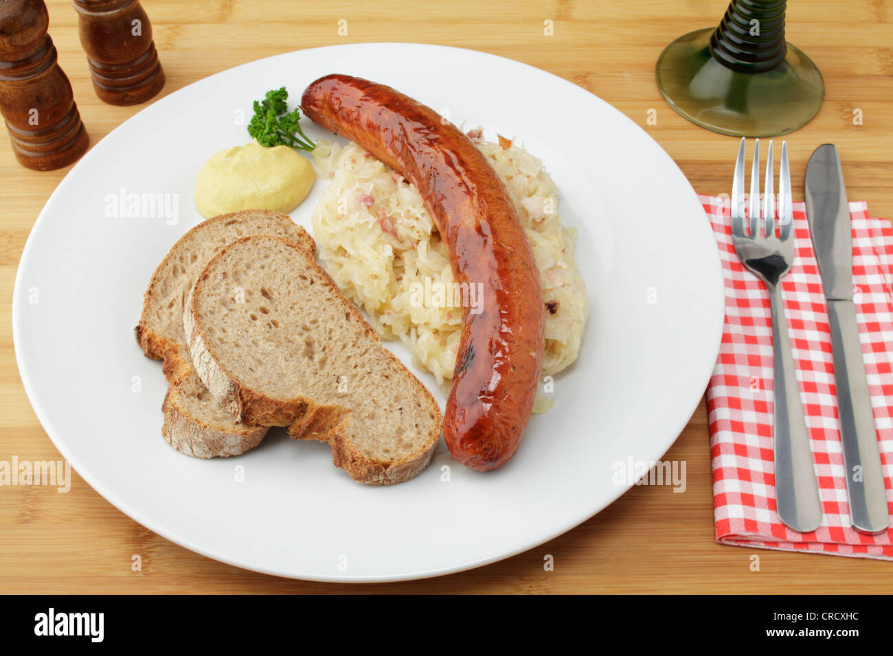 Krakowska smoked spicy Polish sausage on sauerkraut, crusty bread and mustard Stock Photo