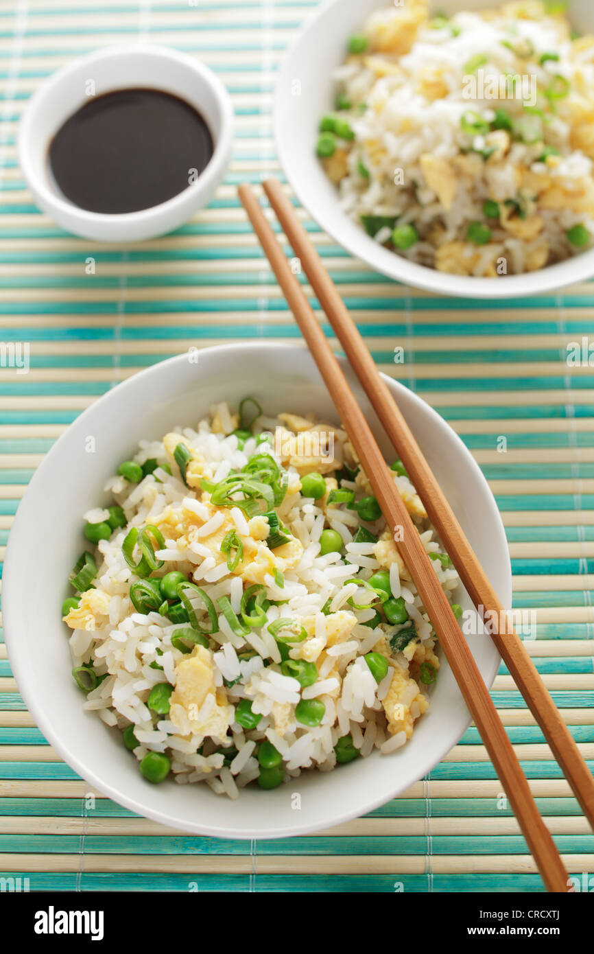 Fried egg rice in a bowl, soy sauce and chopsticks Stock Photo