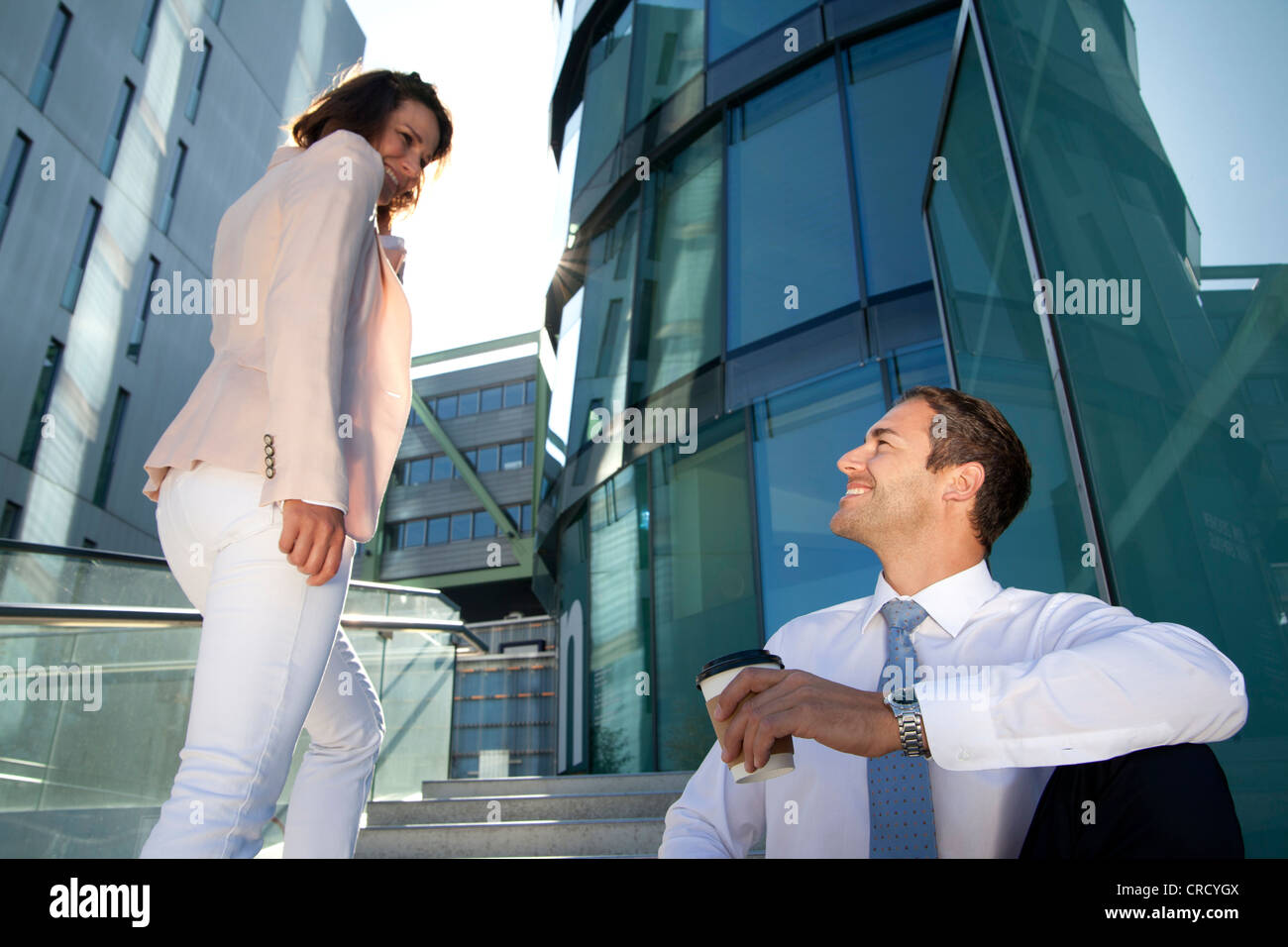 Smiling businessman and businesswoman on stairs Stock Photo - Alamy