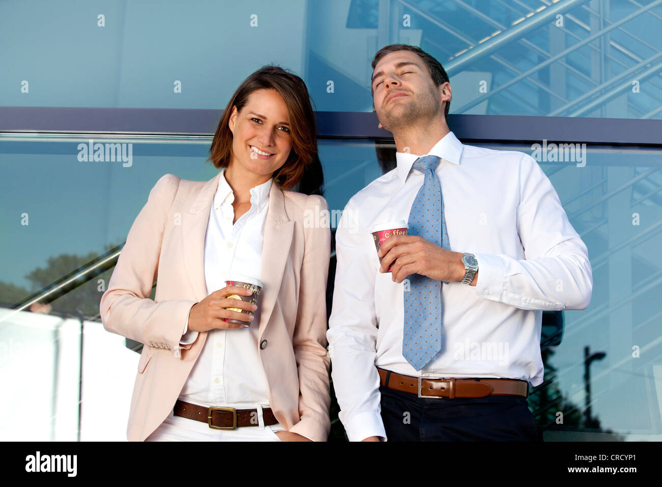 Businessman and businesswoman with coffee to go outdoors Stock Photo
