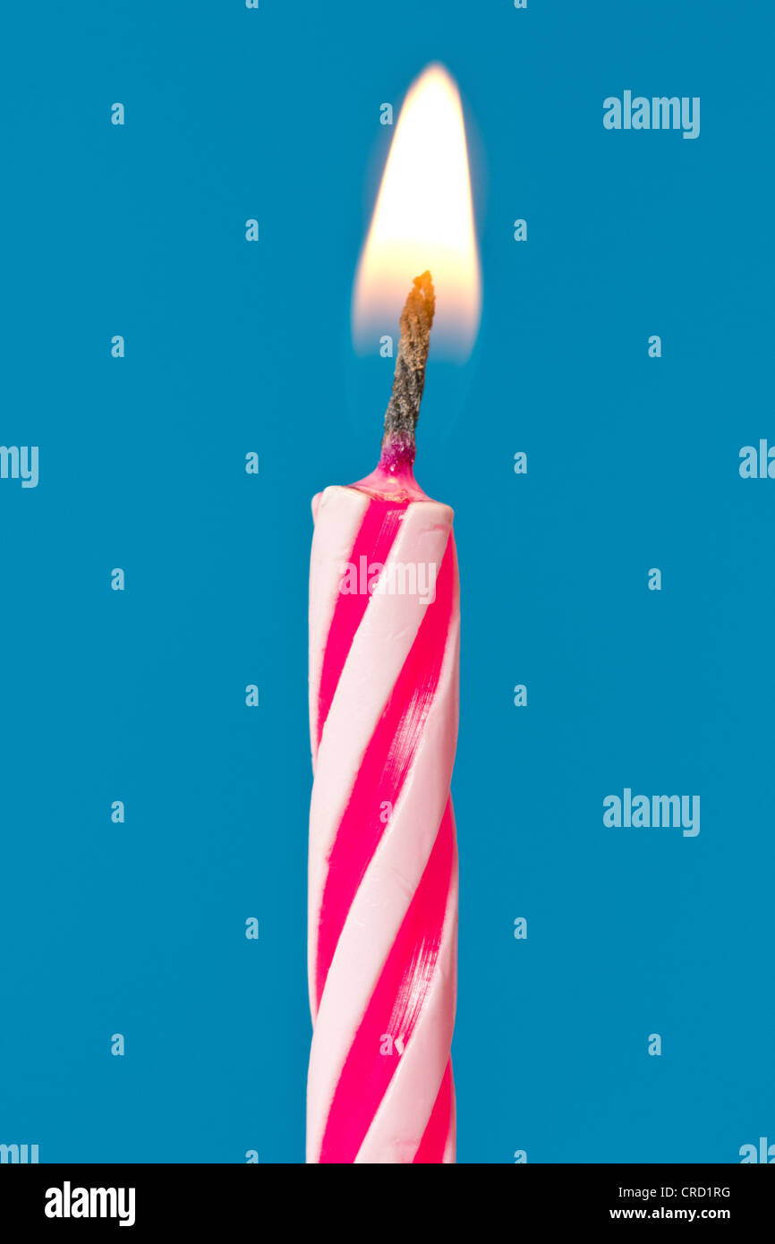 birthday candle burning over a blue background Stock Photo Alamy