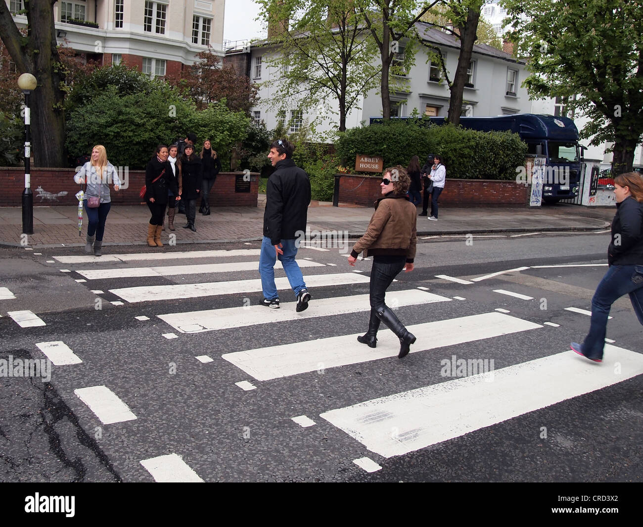 Beatles fans walking across the famous Abbey Road Zebra Crossing, London, England, May 15, 2012, © Katharine Andriotis Stock Photo