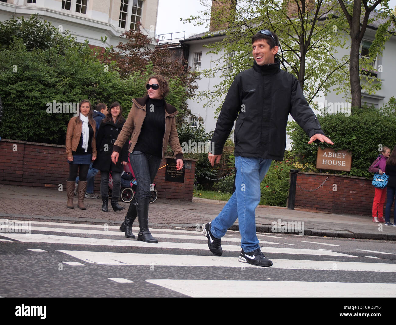 Beatles fans walking across the famous Abbey Road Zebra Crossing, London, England, May 15, 2012, © Katharine Andriotis Stock Photo