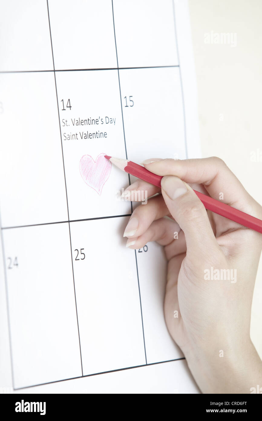 Woman hand drawing heart shape on a calendar Stock Photo - Alamy