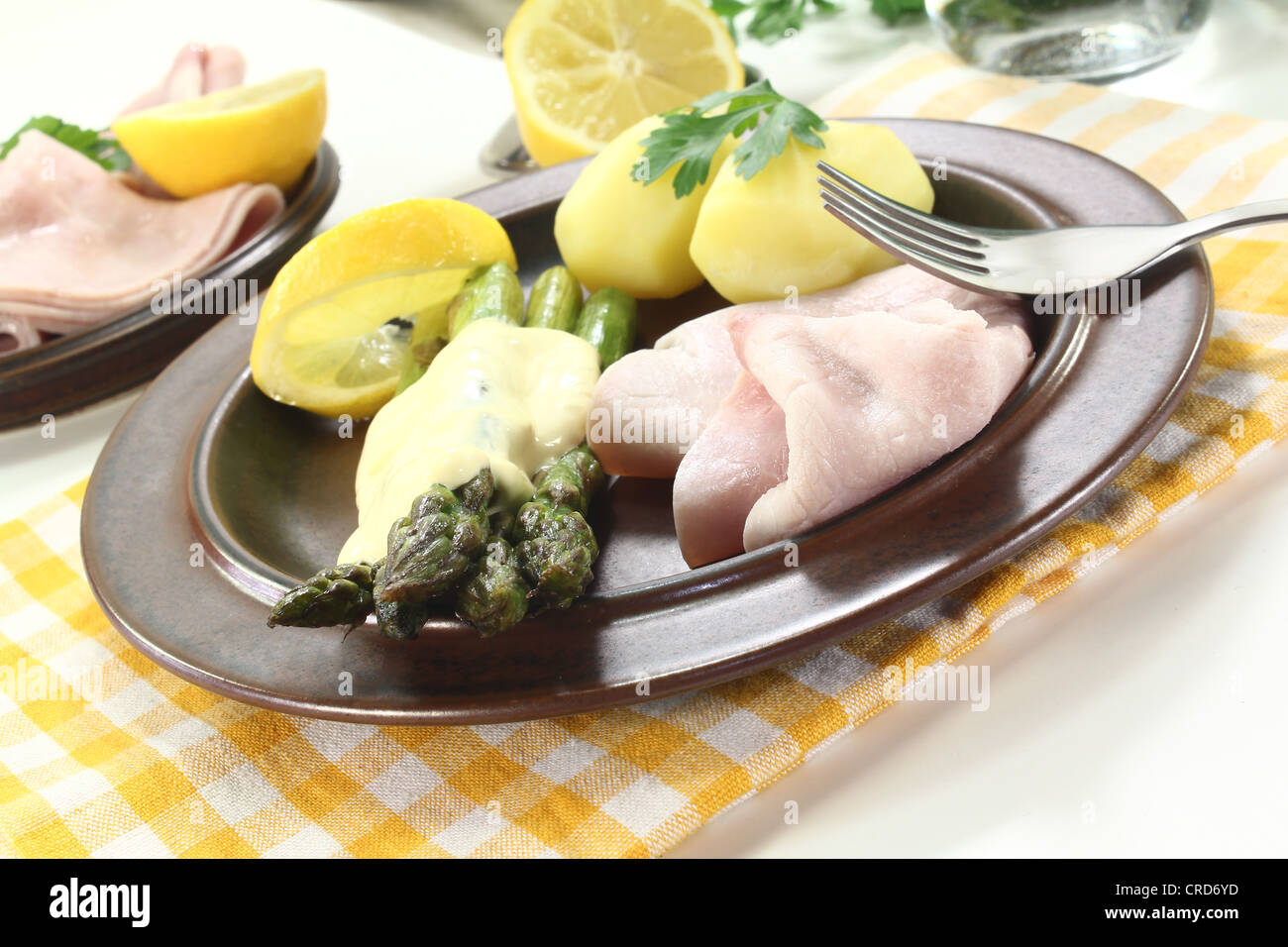Asparagus with hollandaise sauce, potatoes and cooked ham Stock Photo