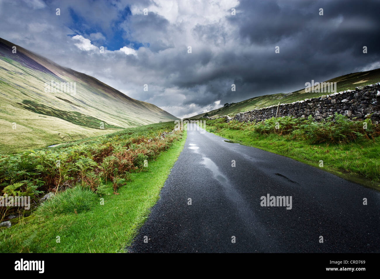 country roads in the Lake district uk cgi car backgrounds summer fluffy clouds hills Stock Photo