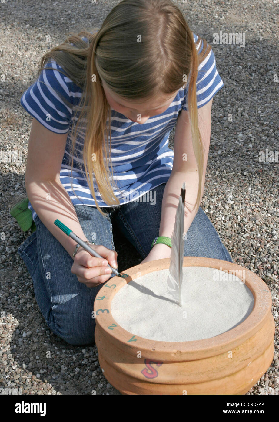 children tinkering a sun dial, time is marked on the basis of the shadow feather's shadow, series picture 5/7 Stock Photo
