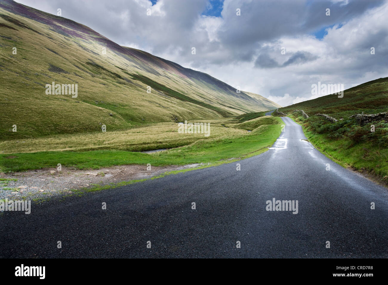 country roads in the Lake district uk cgi car backgrounds summer fluffy clouds hills Stock Photo