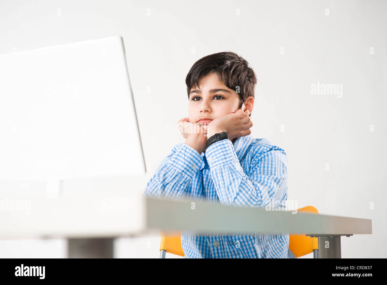 Teenage boy sitting in front of laptop Stock Photo