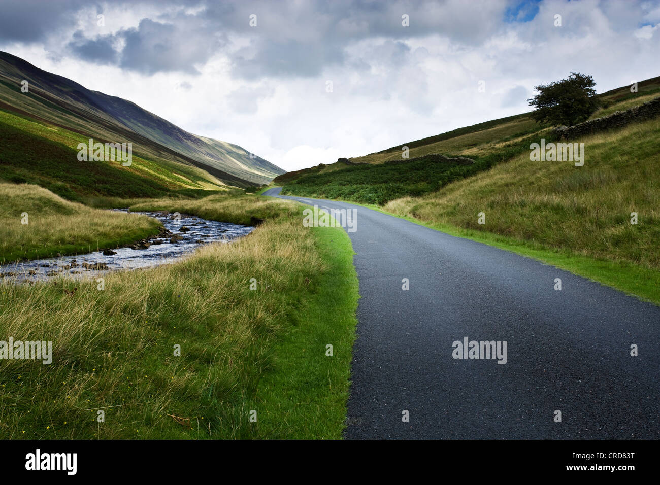 country roads in the Lake district uk  cgi car backgrounds summer fluffy clouds hills Stock Photo