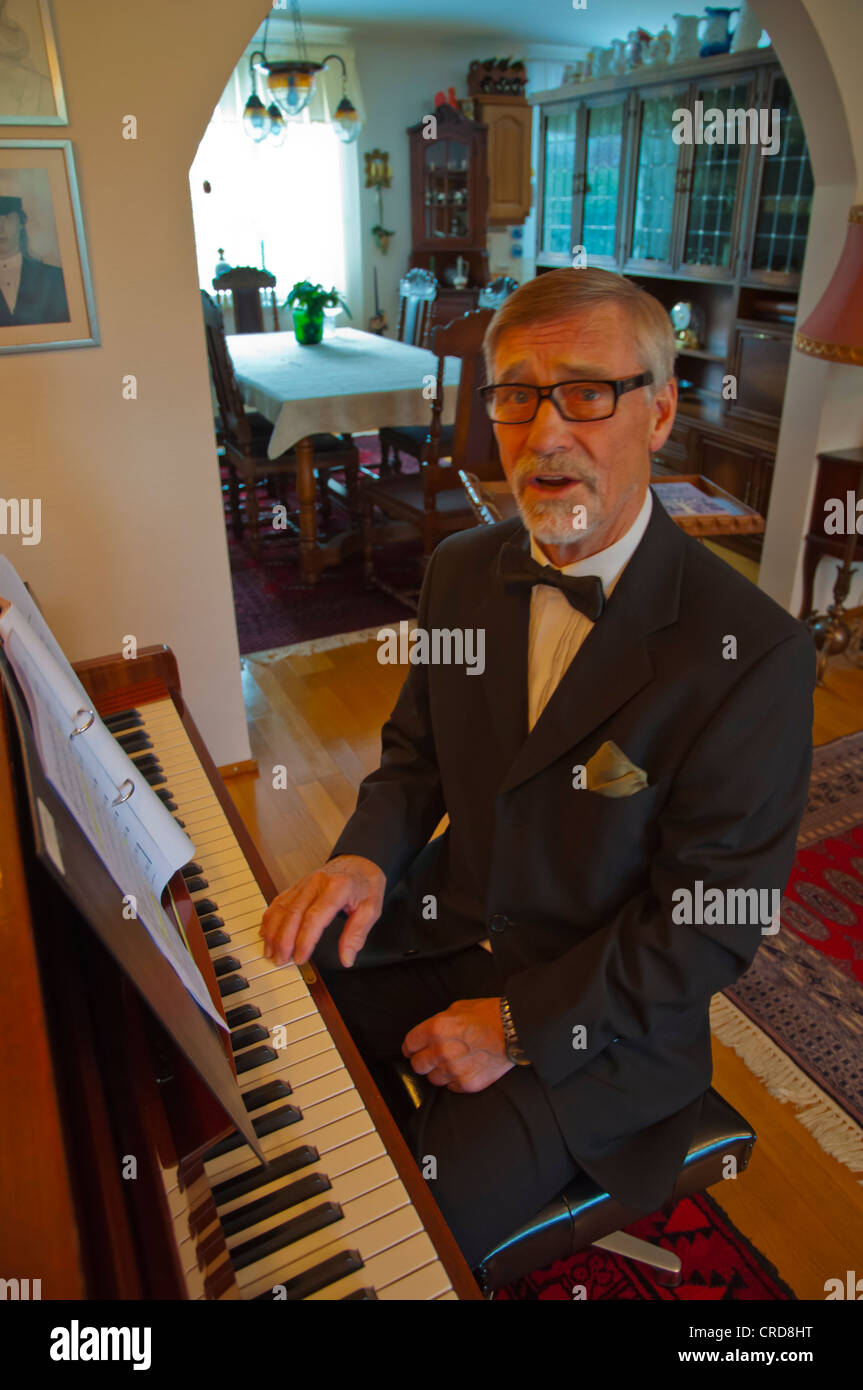 Man in his early 70s practising for choir singing with pian Finland Europe Stock Photo