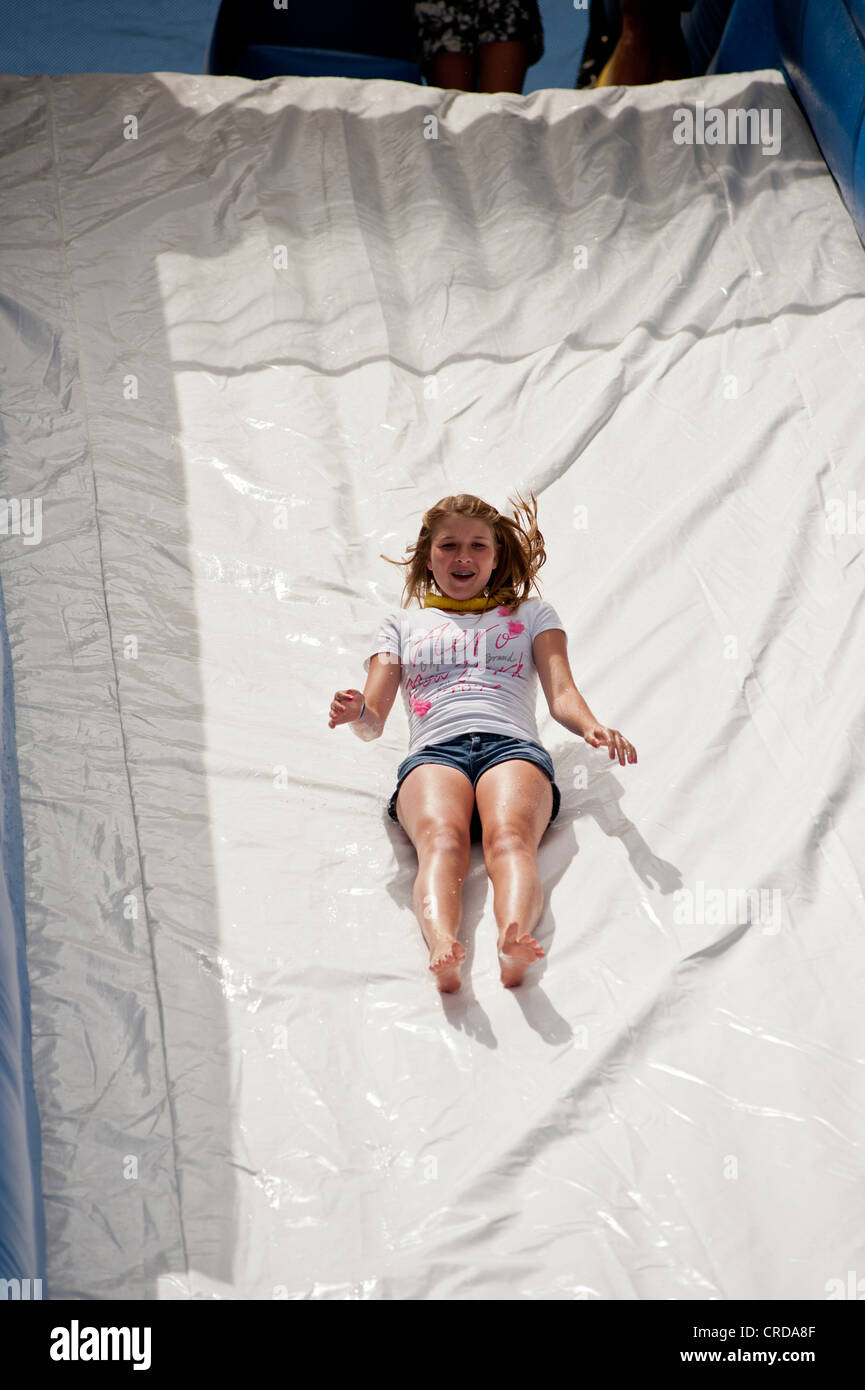 Child sliding down inflateable water slide Stock Photo