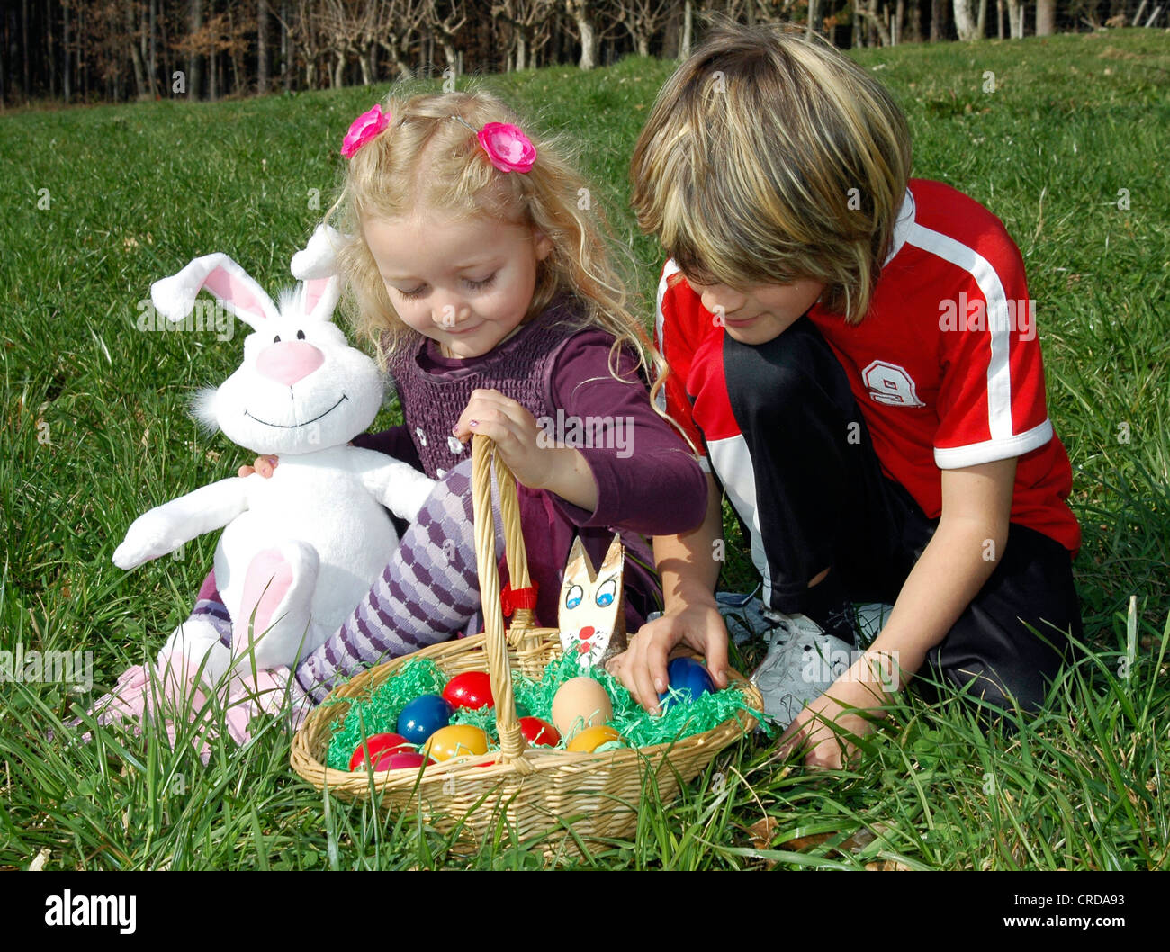 two children with Easter nest in meadow Stock Photo