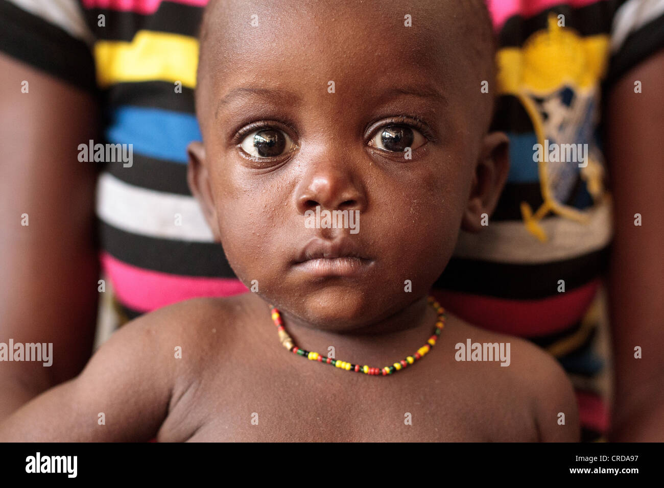 A boy sits on his mother's lap at the Slipway clinic in Monrovia, Montserrado county, Liberia on Monday April 2, 2012. Stock Photo