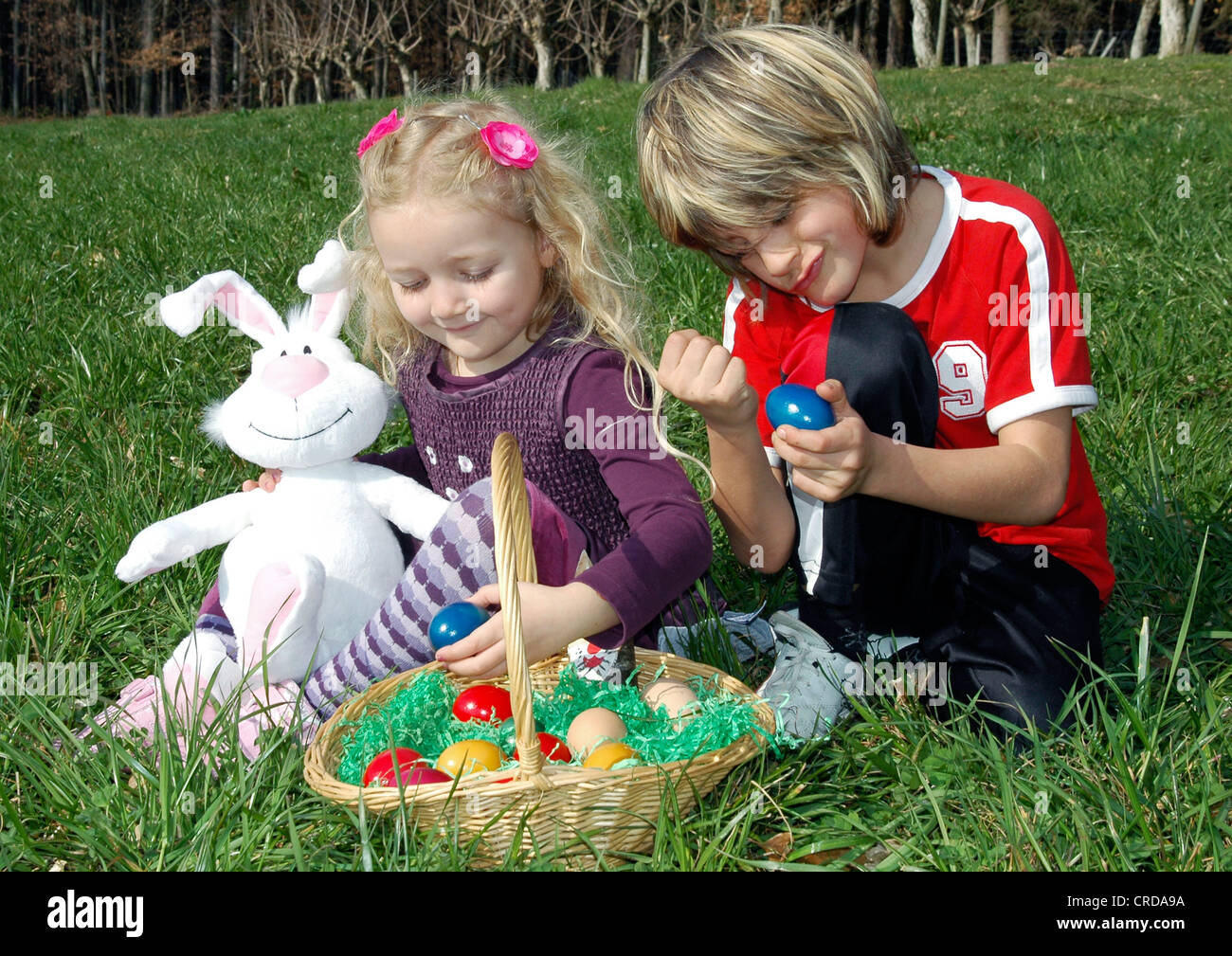 two children with Easter nest in meadow Stock Photo