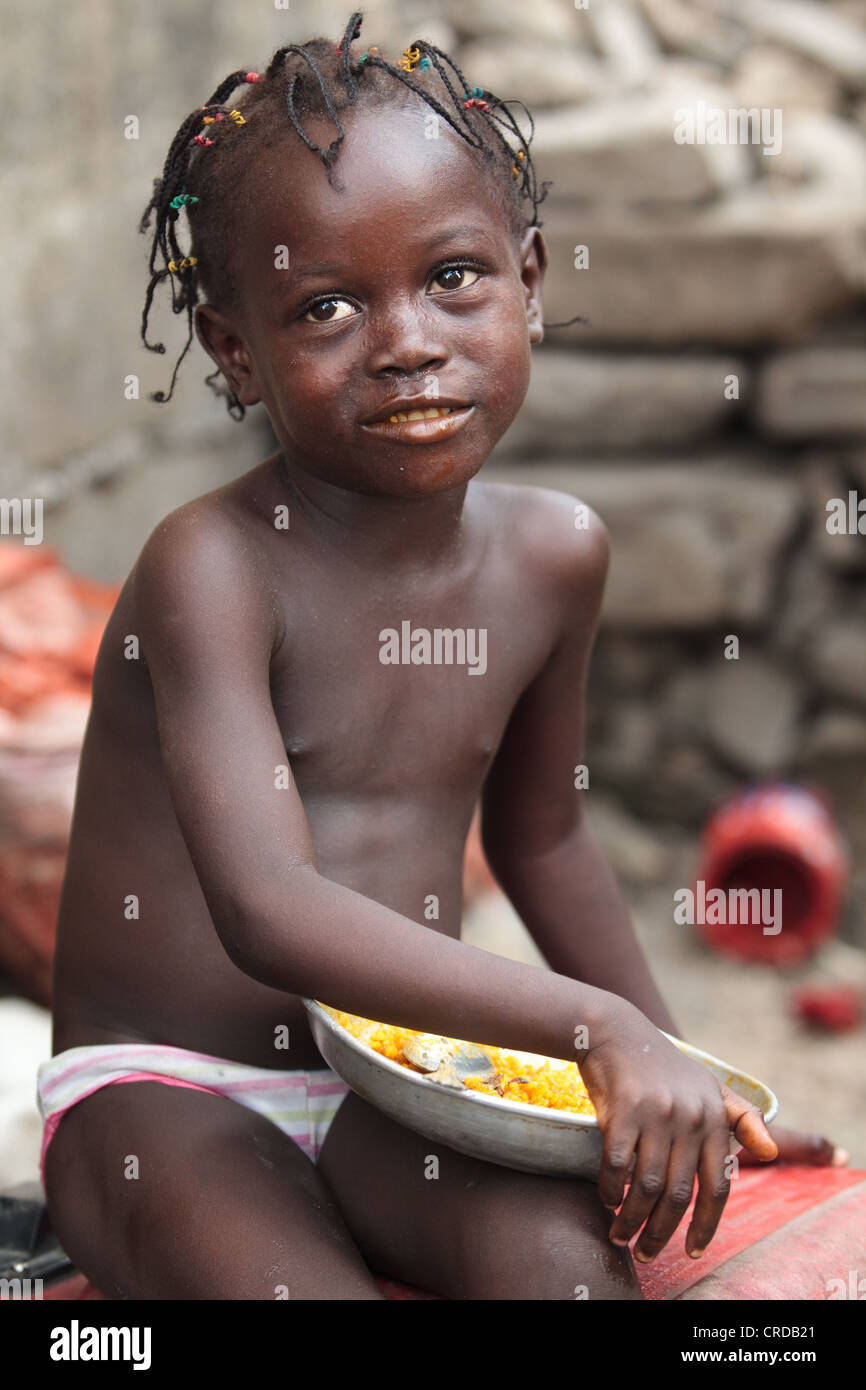 A girl eats from a plate of rice in the West Point slum of Monrovia, Montserrado county, Liberia on Monday April 2, 2012. Stock Photo