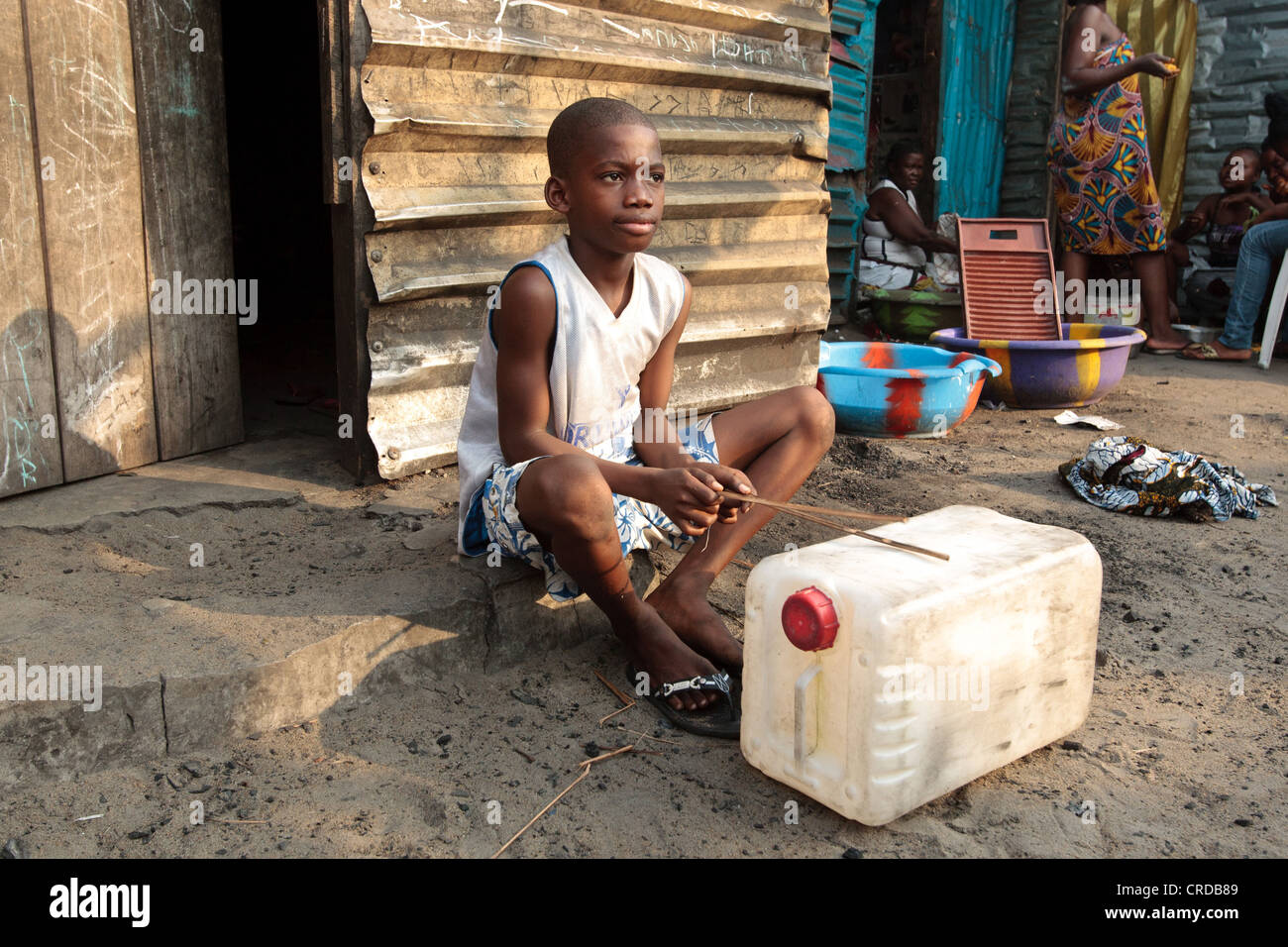 A boy plays drums on a plastic jerrican in the West Point slum in Monrovia, Montserrado county, Liberia on Monday April 2, 2012. Stock Photo