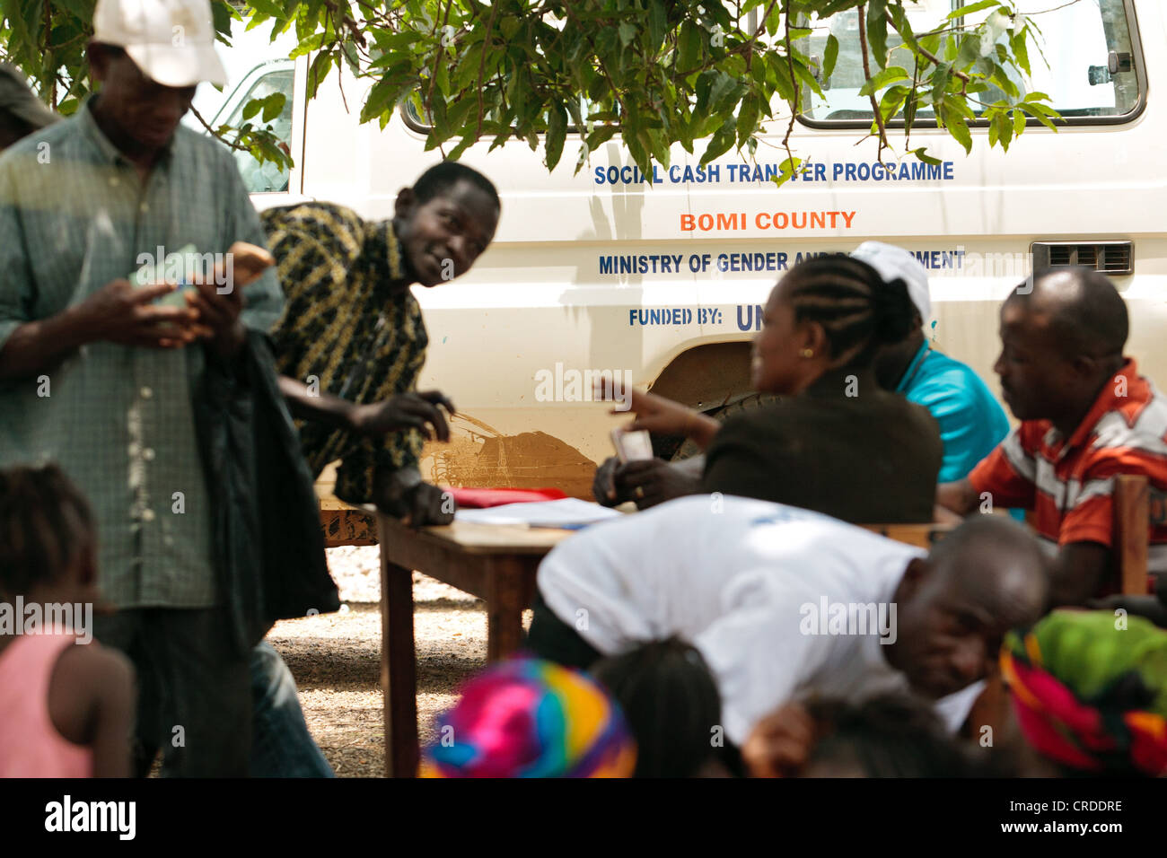 Money is handed out to beneficiaries during a social cash transfer programme distrubution in the village of Julijuah, Liberia Stock Photo