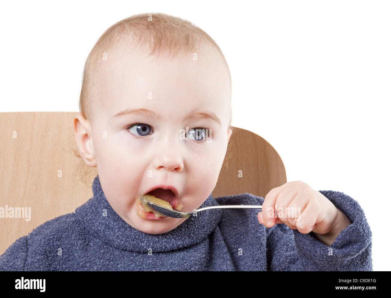 baby eating applesauce studio shot isolated on white background Stock