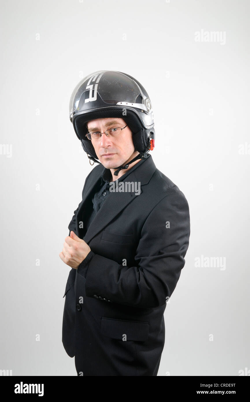 black motorcycle helmet and suit Businessman wearing a black suit and a motorcycle helmet Stock Photo
