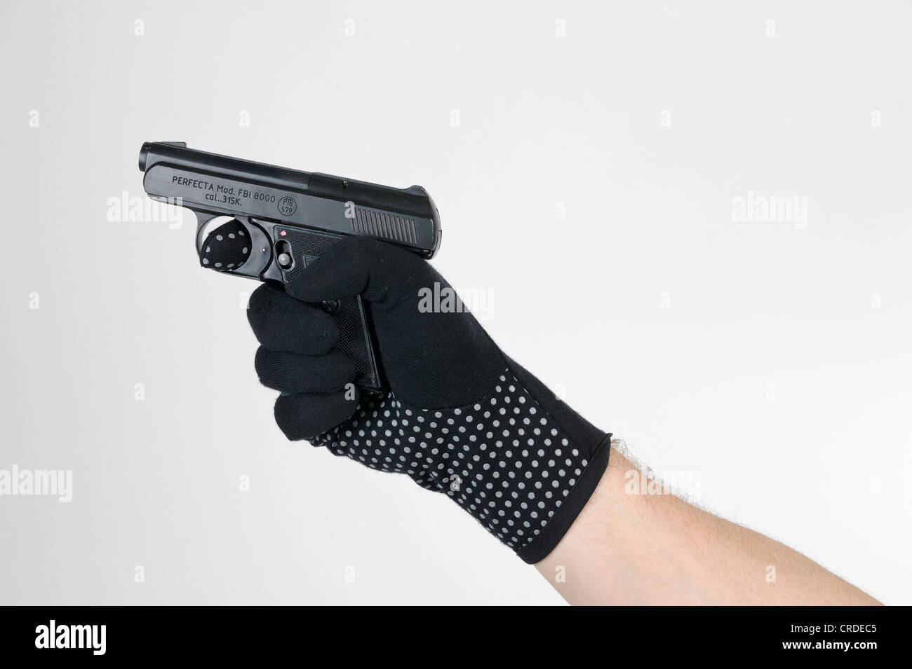 Hand wearing a black glove holding a gun Stock Photo
