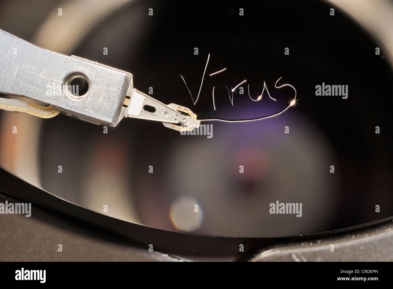 Actuator arm and head of a computer hard drive, with the engraved word "virus" Stock Photo